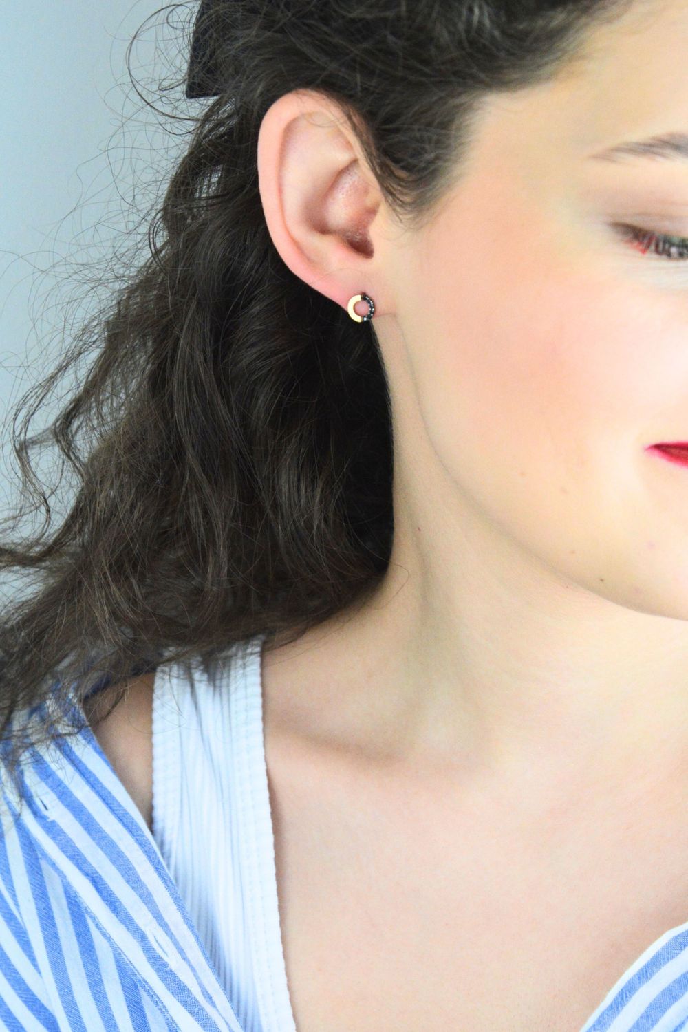 Złote kolczyki celebrytki przy uchu z czarnymi kamieniamisds.jpg